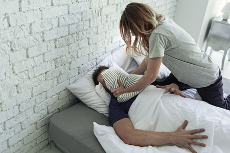 73818567-mad-wife-is-covering-face-of-husband-with-pillow-and-trying-to-suffocate-him